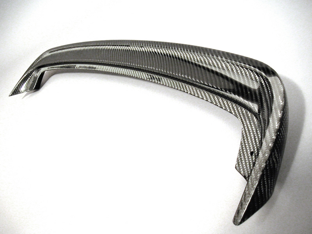 Gloss carbon-fiber rear spoiler lip photographed alone on a white background