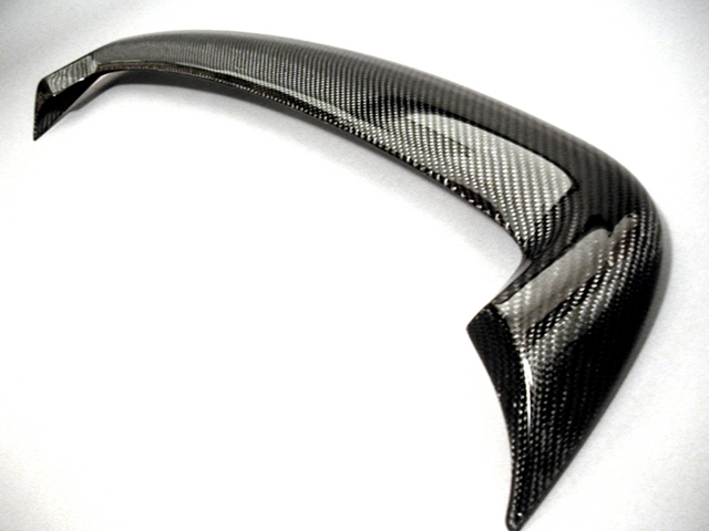 Glossy carbon-fiber curved automotive trim piece on white background