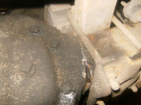 2000 Ford E350 - Close-up view of the underside of a vehicle's differential, showing mechanical components and accumulated dirt.