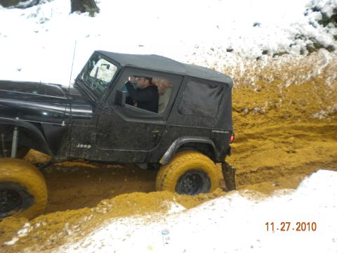 2005 Jeep Wrangler - A black 2005 Jeep Wrangler navigates a muddy trail during winter conditions.