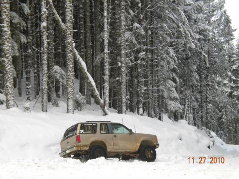 2005 Jeep Wrangler - Ford Explorer stuck in snow on a wooded slope. Date stamp reads 11.27.2010.