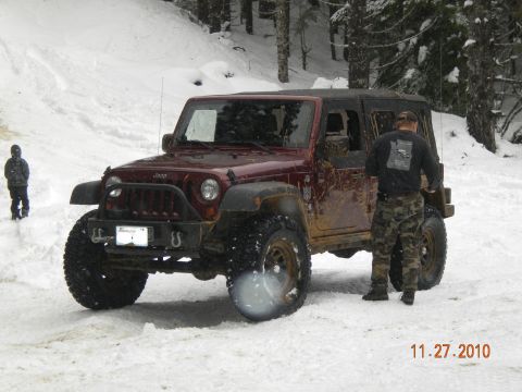 2005 Jeep Wrangler - A maroon Jeep Wrangler is parked in the snow with a person standing next to it.