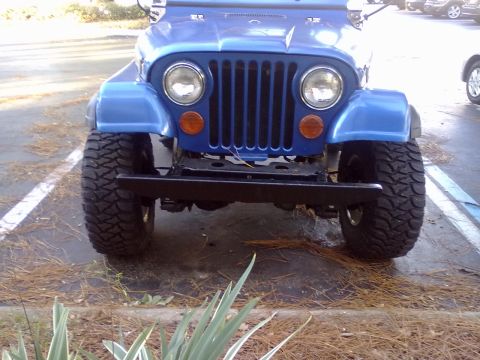 1978 Jeep CJ5 - Front view of a blue 1978 Jeep CJ5, its iconic grille and large off-road tires.