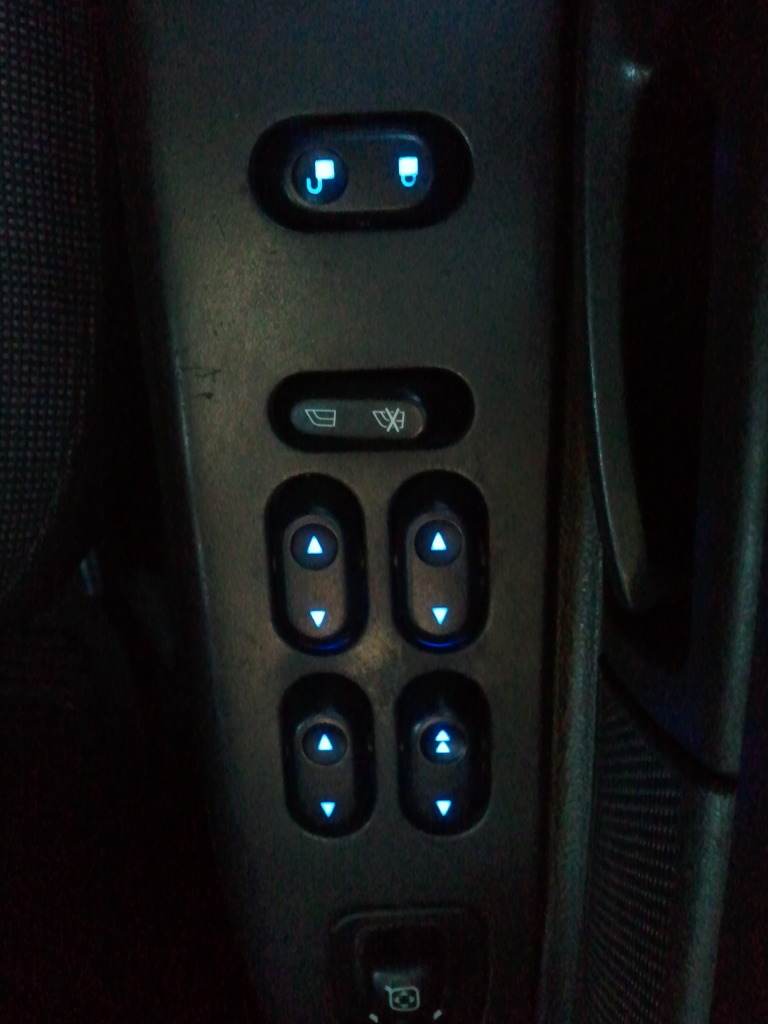 Interior door panel with illuminated power window controls and lock button