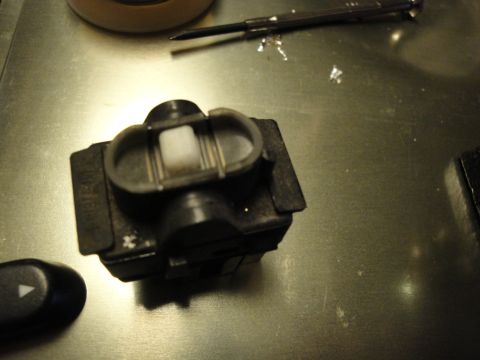 2003 Ford Crown Victoria - Close-up of a car's window switch mechanism and a detached button, with a screwdriver nearby.