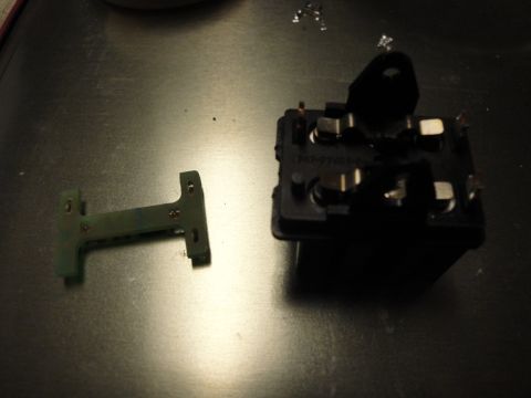 2003 Ford Crown Victoria - Close-up of an automotive relay and a circuit board component, likely for repair or replacement.