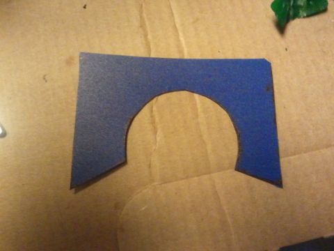 2003 Ford Crown Victoria - A blue gasket with a semi-circular cutout is shown on a cardboard surface, with a Supermotors.net watermark at the bottom right.