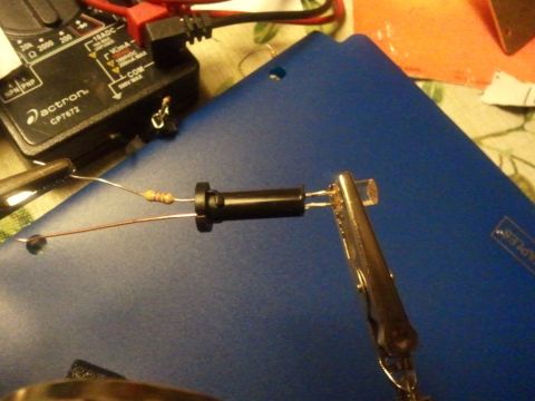2003 Ford Crown Victoria - A close-up shows a circuit being tested with a resistor, LED, and multimeter.