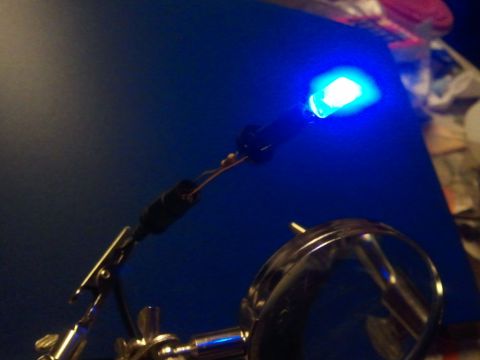 2003 Ford Crown Victoria - A blue LED light is illuminated, mounted on a stand with wires connected.