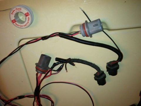2003 Ford Crown Victoria - A headlight wiring harness is shown with connectors and a roll of solder nearby.