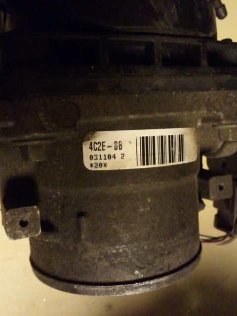 2003 Ford Crown Victoria - Close-up of a throttle body part, showing a label with part numbers and codes.