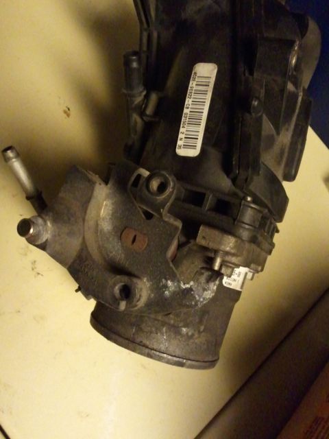 2003 Ford Crown Victoria - Throttle body part with visible label and tubing connections.
