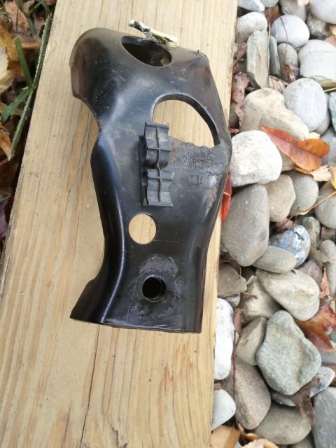 2003 Ford Crown Victoria - This is a black metal bracket with plastic clips, shown outdoors on a wooden surface next to rocks.
