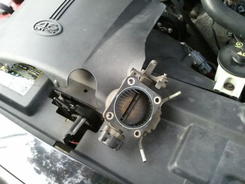 2003 Ford Crown Victoria - A removed throttle body sits on the engine cover of a 2003 Ford Crown Victoria.