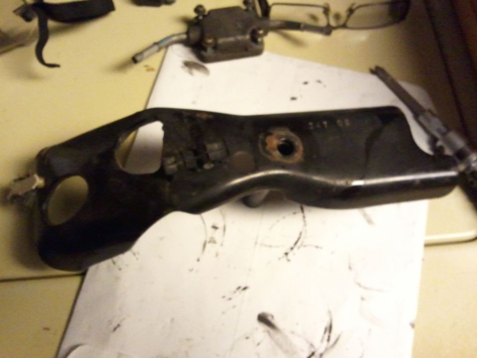 Black metal throttle body bracket with visible part numbers