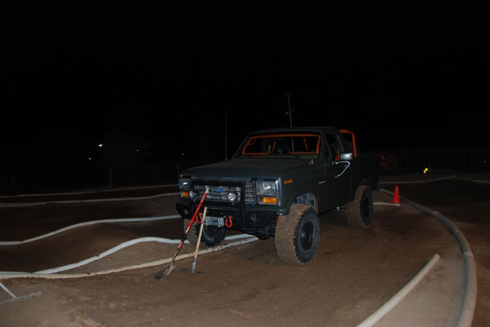 Dark green 1980s SUV with orange roll cage and off-road tires