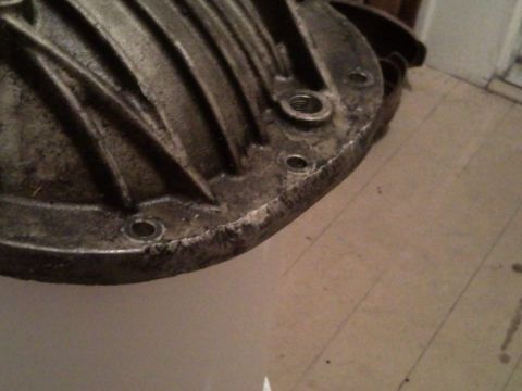 1989 Ford Bronco - A close-up view of a metal differential cover with visible bolt holes and ribbed detailing.