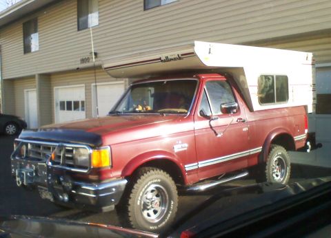 1995 Ford Bronco - This red Ford Bronco is equipped with a camper shell for extended trips.