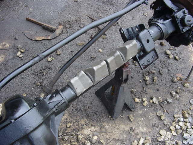 Front driveshaft with double-cardan joint between two painted axle housings on a jack stand
