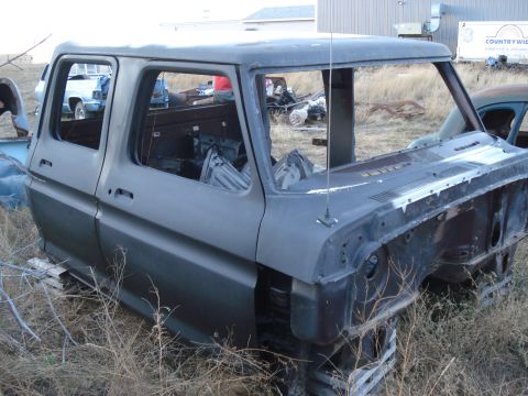 1977 Ford F-150 - This 1977 Ford F-150 cab is missing its engine and front clip, seen in a junkyard setting.