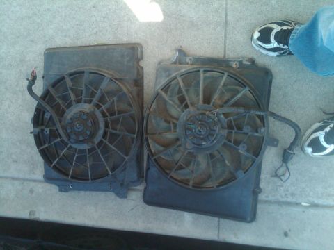 1982 Ford Bronco - Two radiator fans are shown side-by-side on a concrete surface.