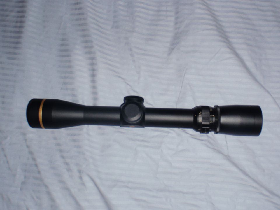 black rifle scope with gold ring on front lens cap