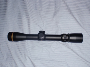 1991 Ford Bronco - A rifle scope is shown against a textured background.