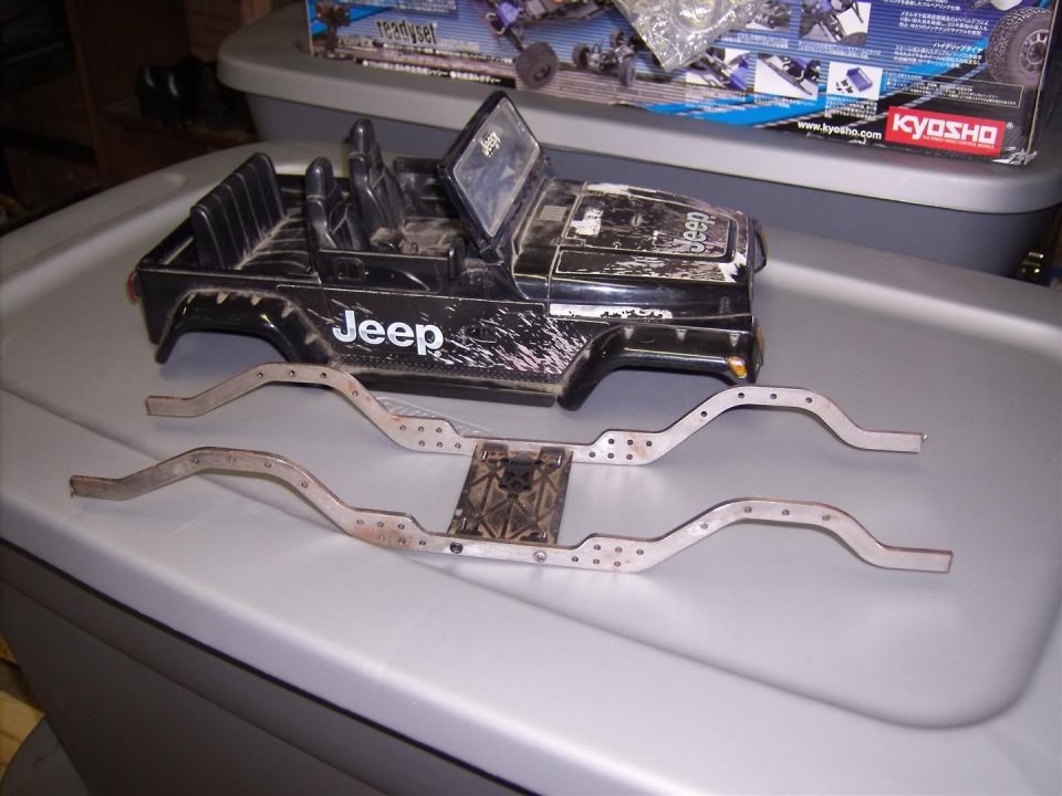 Black RC Jeep body with 'Jeep' logo and two metal chassis frames