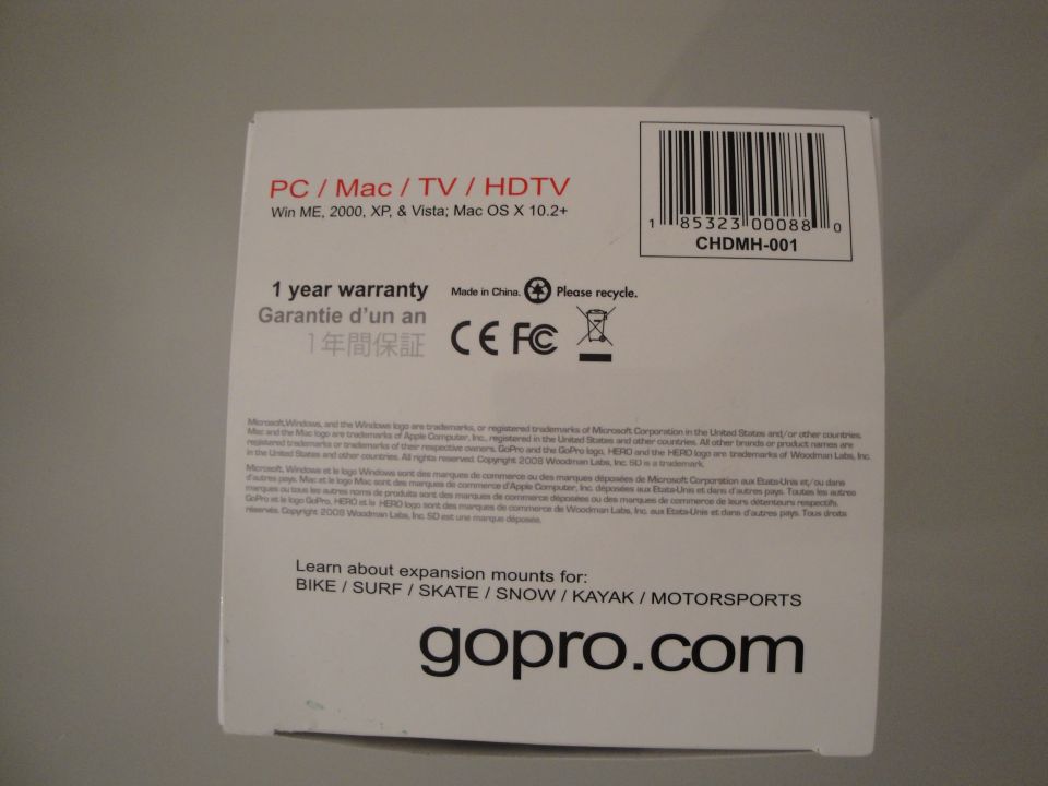 GoPro product box with PC/Mac/TV/HDTV compatibility, 1 year warranty, Made in China, CE, FC, and recycling symbols. Also shows a barcode and gopro.com