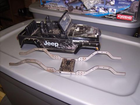 1994 Ford Escort - A toy Jeep body and separate chassis parts are laid out on a surface.