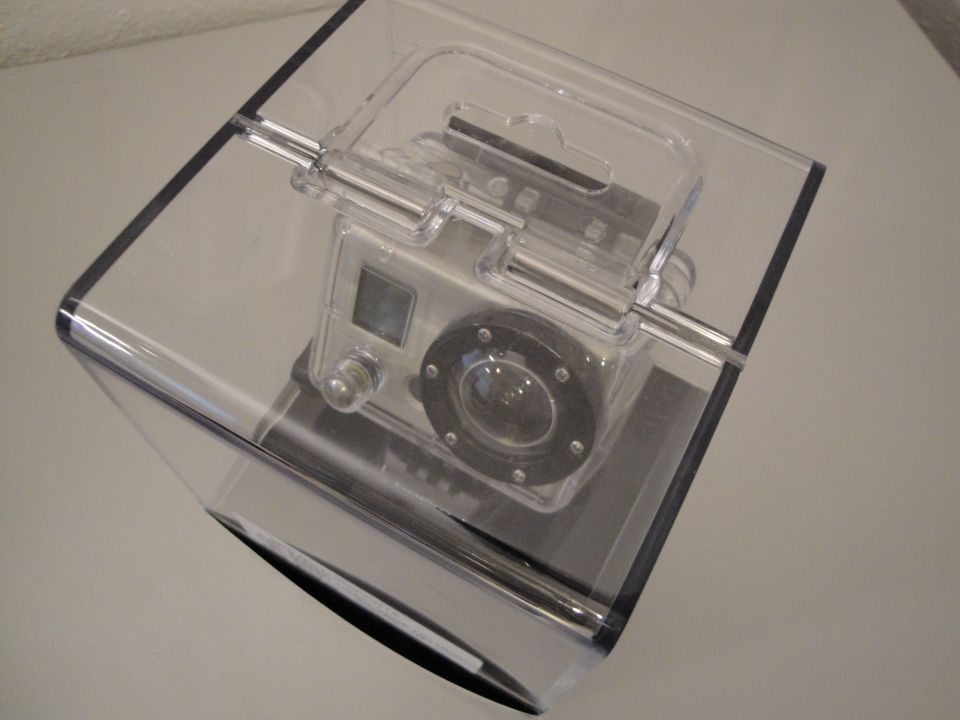 GoPro camera in a clear waterproof housing, resting on a dark surface
