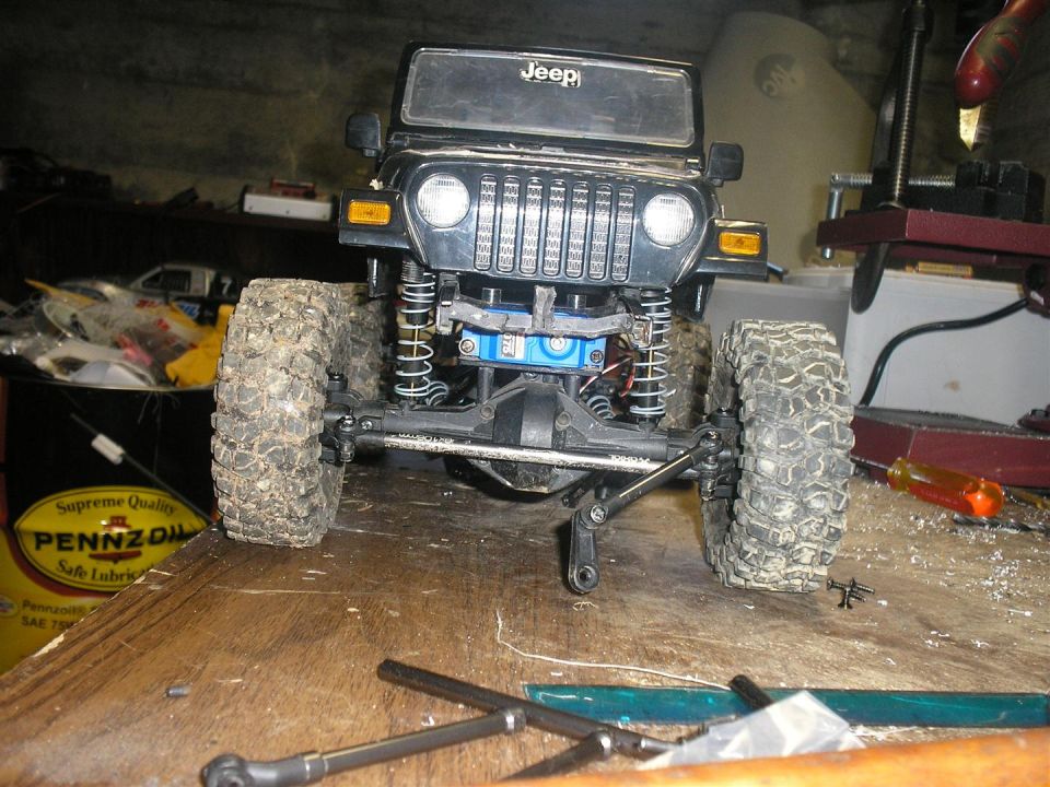 RC Jeep Wrangler on workbench with tools and oil can