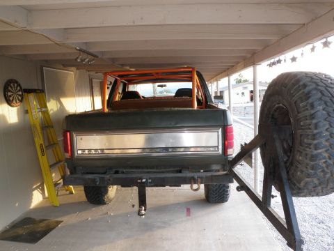 1982 Ford Bronco - This dark green SUV features an orange roll cage and an external spare tire mount on the rear.