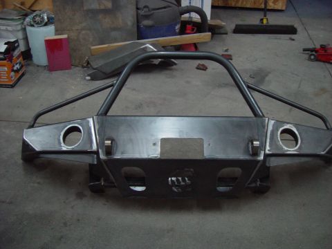 1993 Ford Bronco - A fabricated steel bumper with integrated brush guard sits on a workshop floor.