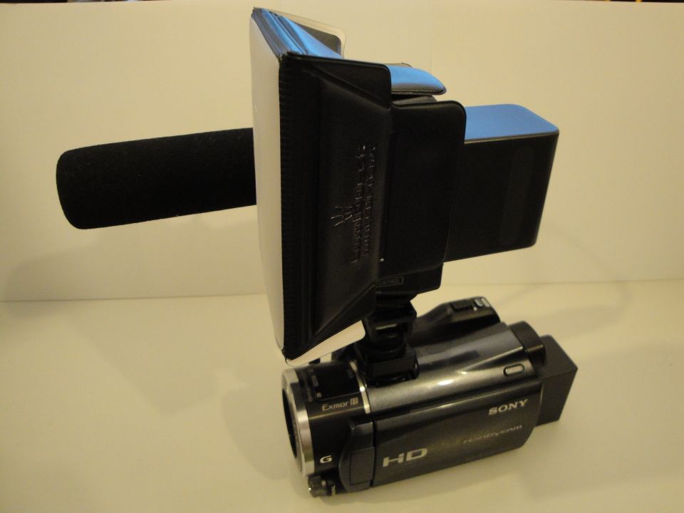 Black Sony HD camcorder with a foam-covered microphone and a white light panel attachment