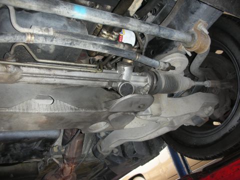 2004 Ford Crown Victoria - Close-up of the steering rack and sway bar assembly from underneath a vehicle.