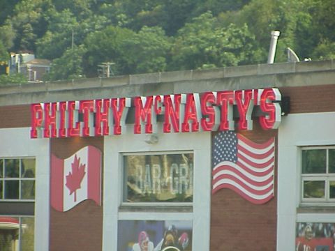 1998 Ford Taurus - Exterior view of Philthy McNasty's Bar & Grill, displaying its prominent neon signage and national flags.