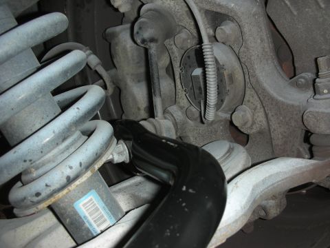 2004 Ford Crown Victoria - The image shows a close-up of vehicle suspension parts, including a sway bar and shock absorber, with a partial barcode visible on the shoc…