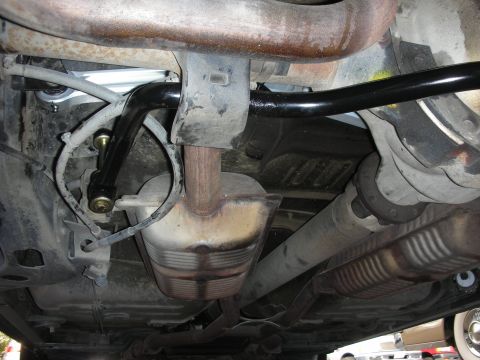 2004 Ford Crown Victoria - Close-up of the rear suspension showing the installation of a new sway bar and its connecting links.