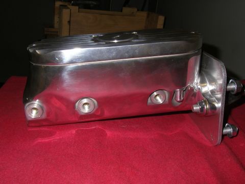 1990 Ford Bronco - A shiny chrome brake master cylinder with a ribbed lid is mounted on a bracket.
