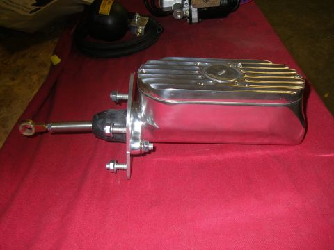 1990 Ford Bronco - Polished aluminum master cylinder with ribbed top, mounted on a red surface.
