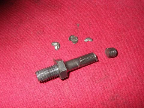 1990 Ford Bronco - A double-ended threaded rocker stud with a hex flat in the middle lies on a red shop rag, surrounded by three curved valve locks/keepers an…