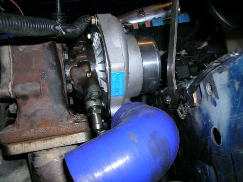 1995 Ford Probe - Close-up of a turbocharger installation, a blue silicone hose and a visible part number on a blue tag.