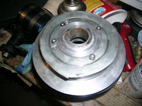 1995 Ford Probe - A metal crankshaft pulley is shown on a workbench, surrounded by various tools and a can.