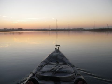 1991 Ford Bronco - Sunrise over a calm body of water, viewed from the bow of a kayak.