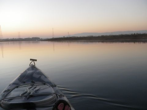 1991 Ford Bronco - View from a kayak on the water at sunrise, with distant power lines and hills visible on the horizon.