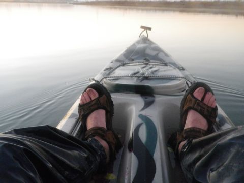 1991 Ford Bronco - View from inside a kayak on calm water, with feet visible in the foreground.