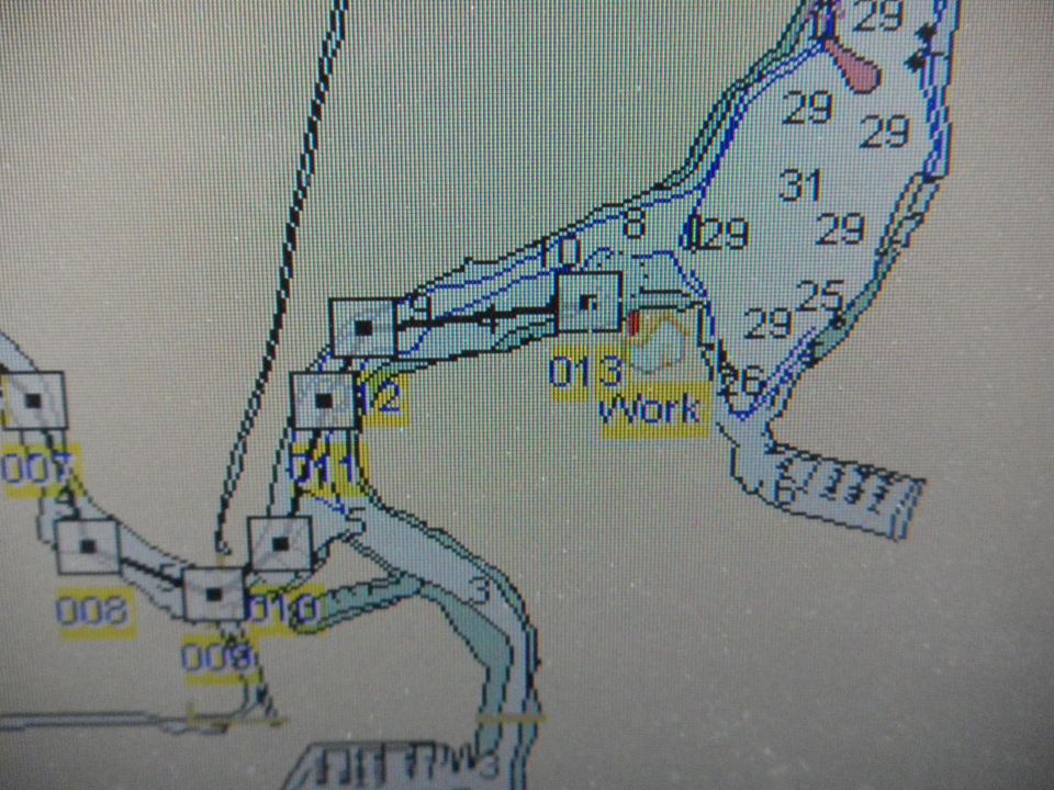 Photo of a GPS chartplotter screen with depth numbers and waypoints