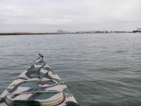 1991 Ford Bronco - View from a camouflaged kayak on the water, with industrial buildings visible on the distant shoreline.