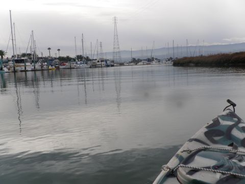 1991 Ford Bronco - A kayak glides through a marina filled with various boats under an overcast sky.